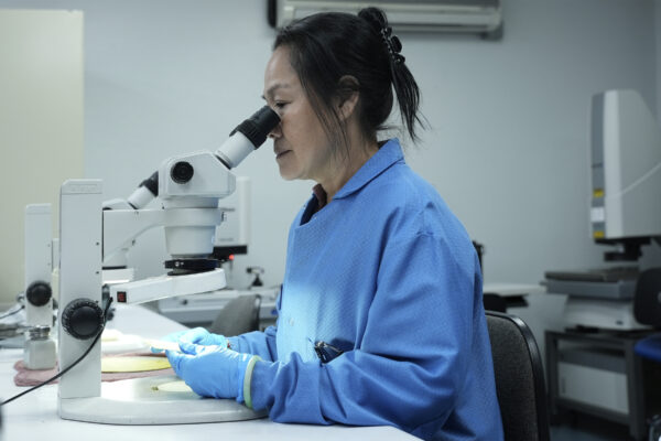 Un employé d’IntriPlex en train d’observer à travers un microscope du système de stéréomicroscope de Nikon.